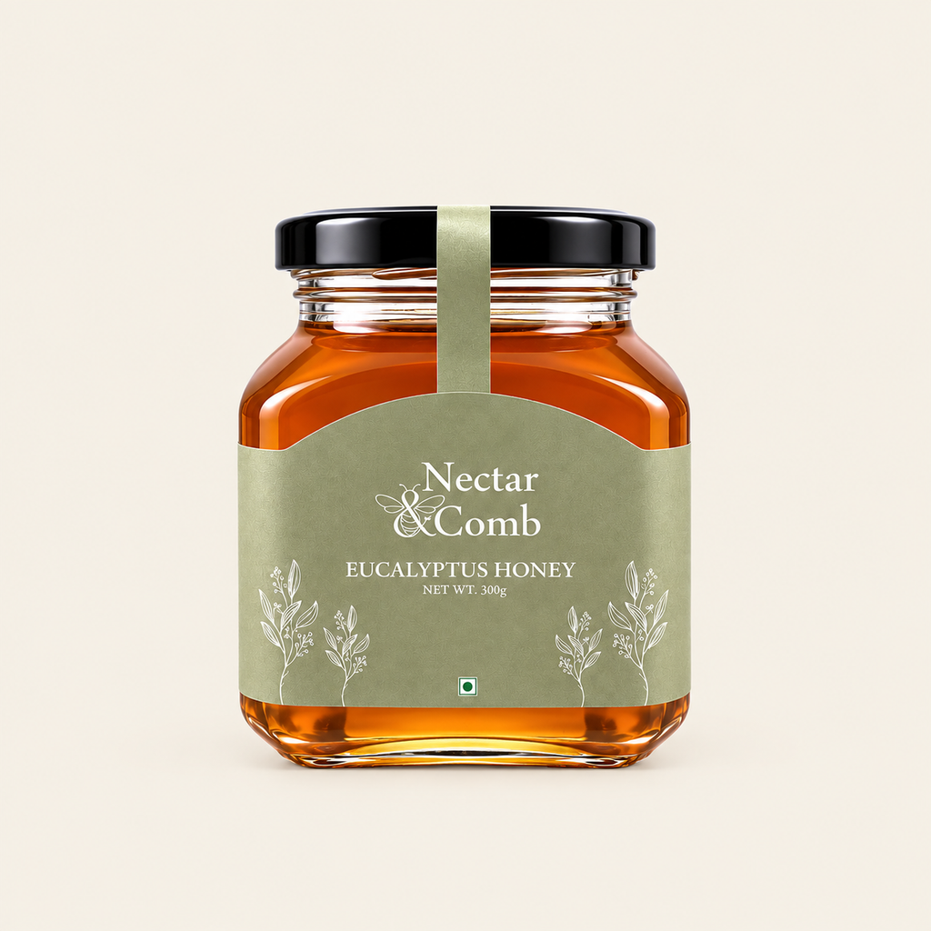 A glass jar of Nectar & Comb Eucalyptus Honey with a black lid and a sage green label, centered on a light beige background.
