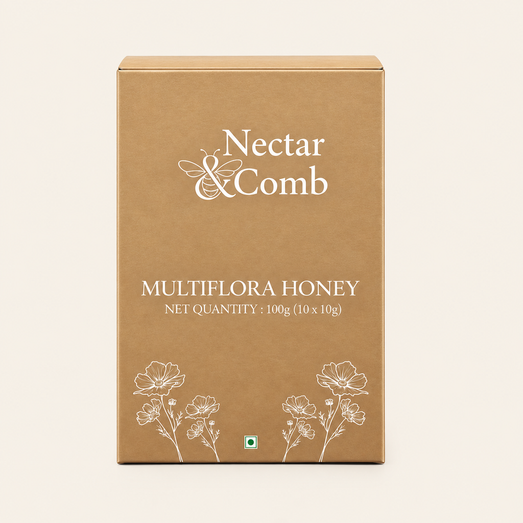 A rectangular brown cardboard box of Nectar & Comb Multiflora Honey, featuring white text and floral line drawings on a light cream background.