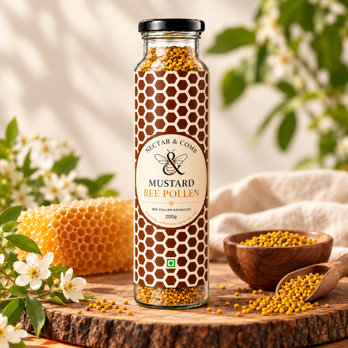 A glass jar of Mustar & Comb Mustard Bee Pollen granules stands on a wooden slice surrounded by honeycomb, small white flowers, and wooden bowls of pollen. The jar has a black lid and a label with a brown and white honeycomb pattern.