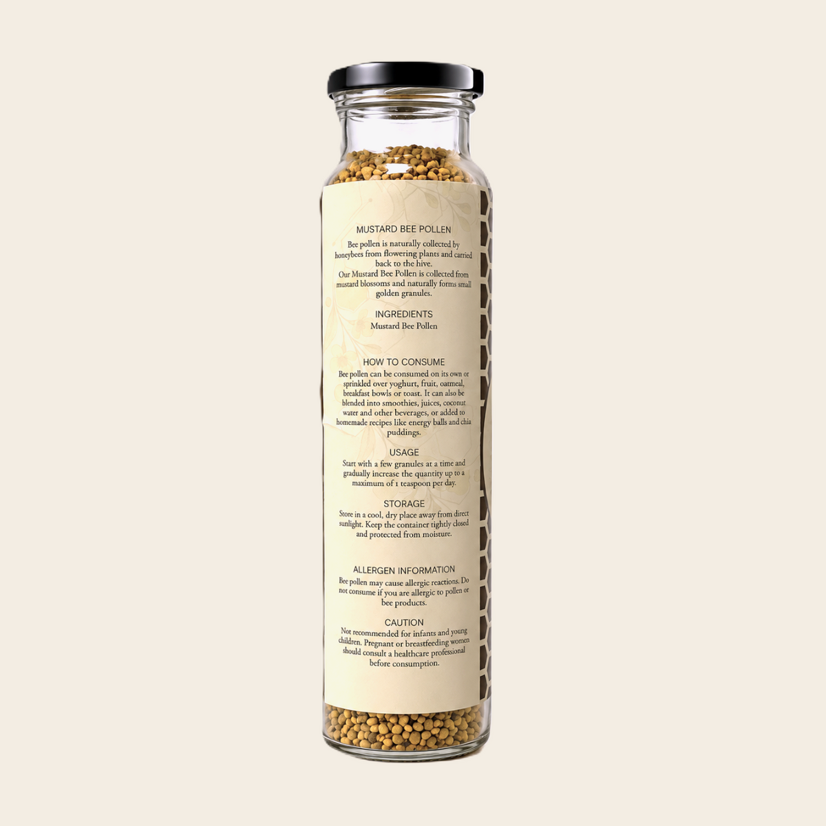 A clear glass jar filled with mustard seed pollens, featuring a black screw cap and a detailed product label with text, set against a solid off-white background.