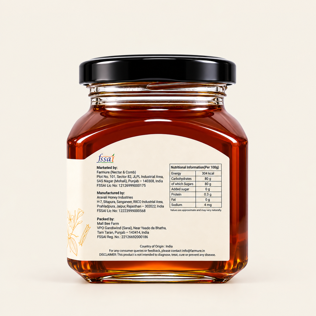 A glass jar of FSSAI certified honey with a black lid, showing amber-colored honey inside and a detailed white label with text and a gold bee illustration, set against a solid off-white background.